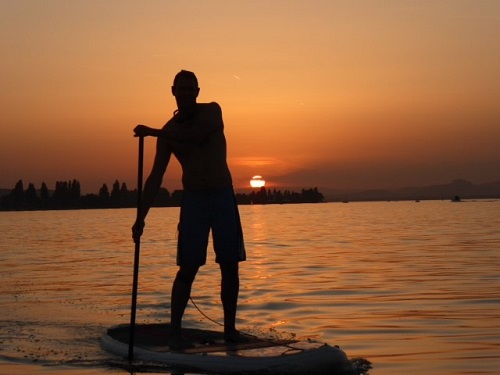 La Canoa Geschaeftsführer Kai König beim Stand Up Paddling im Sonnenuntergang auf dem Bodensee